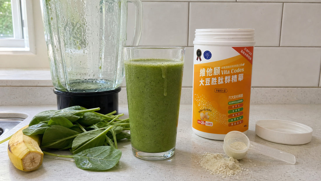 Green smoothie freshly blended beside a tub of Vita Codes soy peptide powder and a scoop on a kitchen counter
