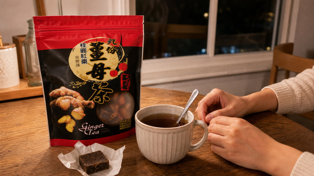 Mug of brewed Taiwanese ginger tea with an unwrapped brown sugar ginger cube beside the Jiufen ginger tea pouch