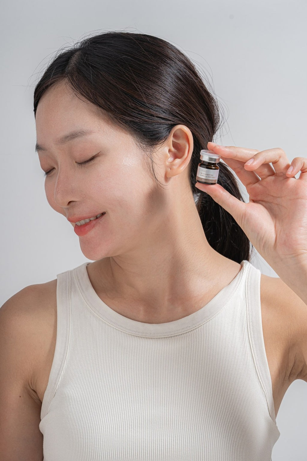 Model holding JAYSUWAN Rejuvenating Miracle Ampoule vial